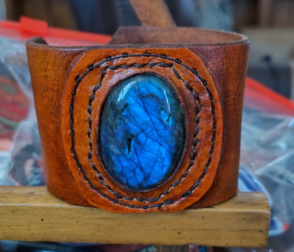 Blue stone in leather wrist strap.
Cost $ 40.00 V Vegan leather 